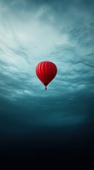 Obraz premium A vibrant red hot air balloon drifting serenely in a sky filled with soft blue clouds.