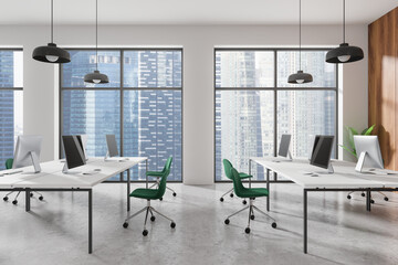 Office coworking interior with pc monitors in row, panoramic window