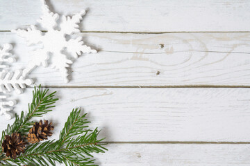 Fototapeta premium Christmas decorations on a wooden background: Christmas tree balls, branches, snowflakes and candy canes, top view, copyspace
