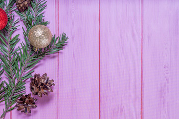 Christmas decorations on a pink wooden background: Christmas tree balls, branches, snowflakes and candy canes, top view, copyspace