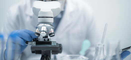 Scientist or Medical worker use microscope look microbiological analyze developmental of viral and Biotechnology research in science lab biochemical samples in advanced scientific laboratory