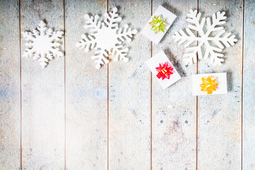 White decorative snowflakes and giftbox on a wooden background, copy space