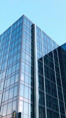 Modern office building with reflective glass windows against a clear blue sky, blue, office park, commercial