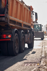 Heavy construction machines and truck outdoors for public street reconstruction.