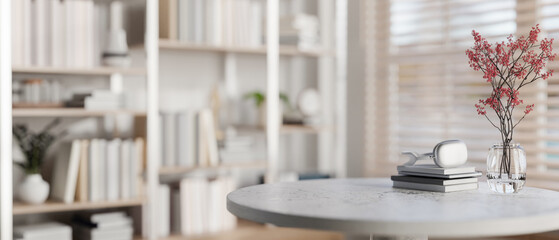 A space for displaying products on a round table with a large bookshelf in the background.