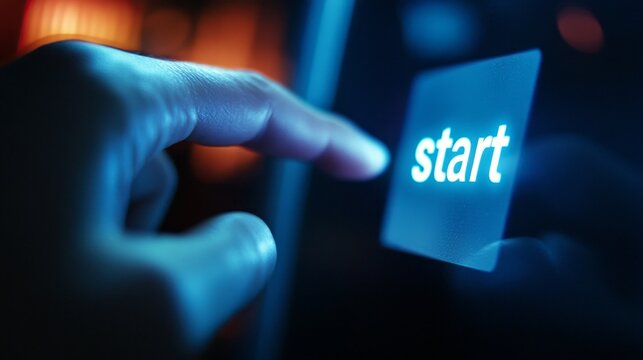 A person is pointing to the start button on a device