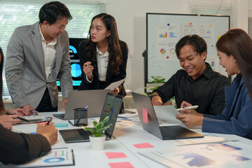 Financial analyst analyzes business finance reports on laptop and graph documents during corporate meeting discussions showing successful teamwork, business meeting ideas, marketing.