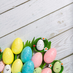 Easter background with copyspace. Colorful tulips and decorative eggs on wood, top view