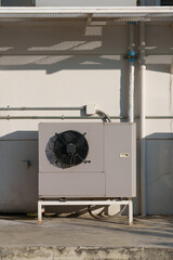 Air compressor or air condenser unit located on support outside building to heat released...