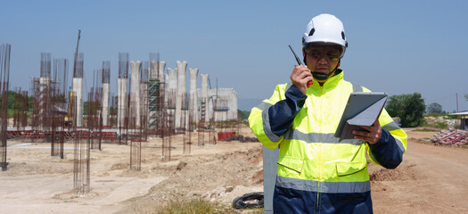 Engineer or architecture worker wearing safety uniform surveying and working at building structure checking blueprints construction site road general job details business concept architecture road