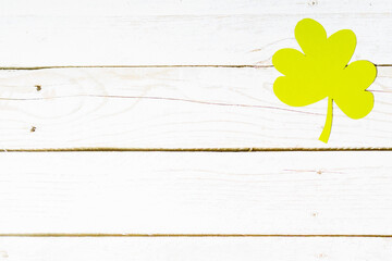 Clover leafs on white wooden background, top view, copy space. Concept of luck St. Patrick's Day