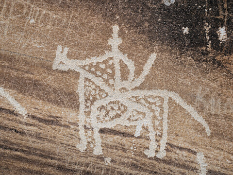 Closeup view of ancient horse and rider carving on rock: detail of antique silk road era petroglyph, Langar, Wakhan Corridor, Gorno-Badakhshan, Tajikistan Pamir