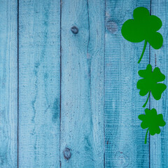 Green four leaf clovers on wooden background top view. Happy St. Patrick's Day greetings