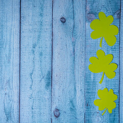 Green four leaf clovers on wooden background top view. Happy St. Patrick's Day greetings