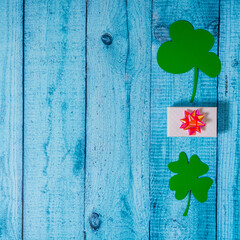 Green four leaf clovers and giftbox on white wooden background top view. Happy St. Patrick's Day greetings © Mikhail Taratonov