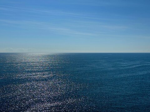 Wide ocean blue shiny water surface and blue sky 