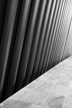 A striking black and white image showcasing the abstract diagonal lines of an architectural structure, evoking feelings of order and simplicity in modern design.