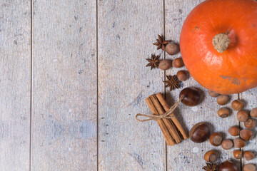 Pumpkin, chestnuts, anise, cinnamon, hazelnuts on a wooden background. Top view, copy space