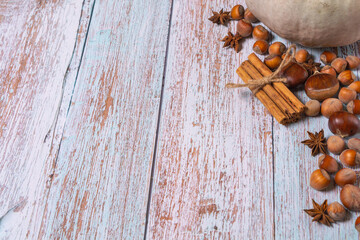 Pumpkin, chestnuts, anise, cinnamon, hazelnuts on a wooden background. Top view, copy space