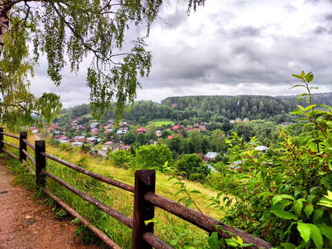 A scenic view of Ples, Russia with green hills and traditional houses under a cloudy sky