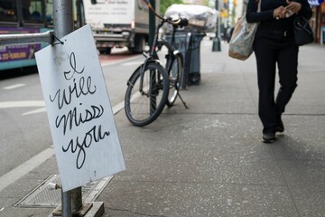 Sidewalk in NYC featuring an 'I will miss you' sign