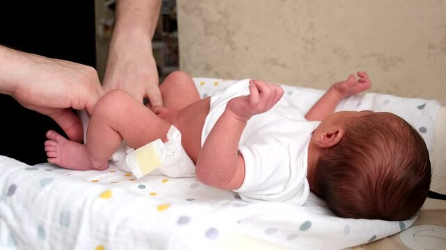 Caregiver Changing Diaper of Newborn Baby