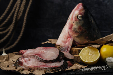 Sliced ​​raw fish on dark background. Fish head and slices of raw fish
