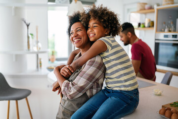 Portrait of african mother hugging with her daughter, enjoying moment of love, having fun together