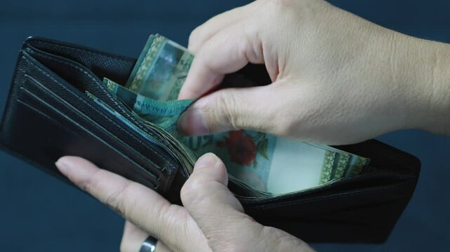 Man counting malaysian ringgit banknotes