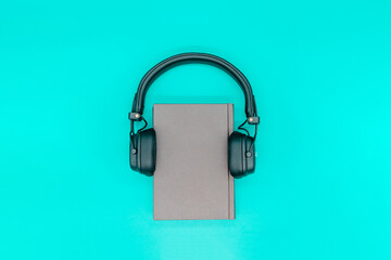 Paper book with headphones, concept of listening audiobooks and podcasts