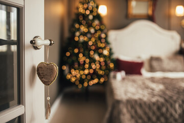 Blurred defocused Christmas tree with festive lights in a cozy living room.