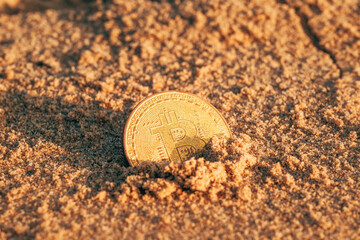 Bitcoin cryptocurrency golden coin in beach sand