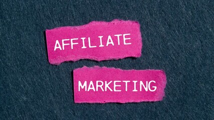 Affiliate marketing message writing on ripped pink torn paper pieces on a gray background. Conceptual affiliate marketing symbol.