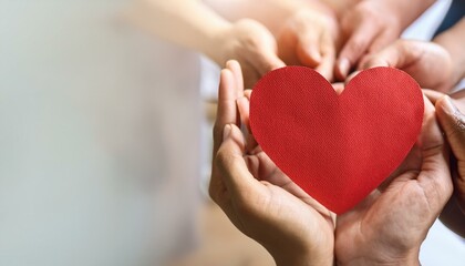 Obraz premium Top view of multiethnic people hands holding red paper heart symbol. Group of people standing in circle, promoting unity, love and support for World Organ Donation Day. Charity and altruism