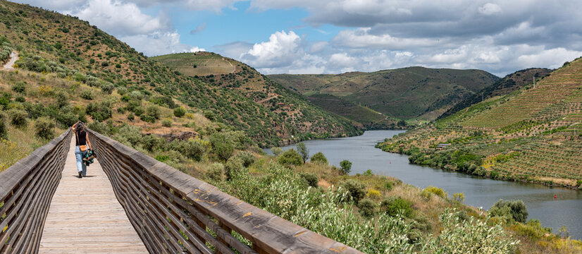 A young woman walking on a wooden boardwalk in the Douro and Coa valley on the footsteps of the famous stone age Coa petroglyphs