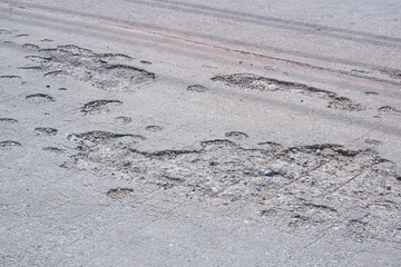 The old damaged concrete road background with worn and broken texture on surface