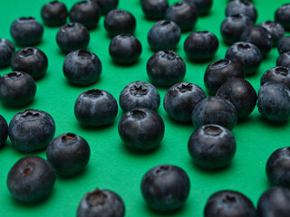 Individual blueberries on a green background are spaced apart in lines