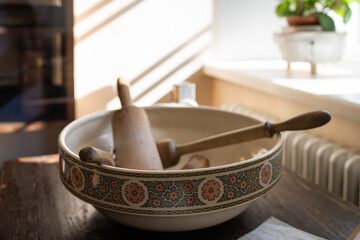 Vintage ceramic bowl with kitchen utensils. An old-fashioned kitchen interior.. Set of ancient kitchen utensils, retro equipment of grandmother, kitchenware of the old days.