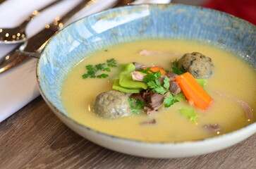 close view of traditional Czech food, Kaldoun goose soup, served food on a plate in a restaurant, wooden table, Saint Martin's goose, traditional Czech holiday food