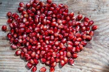pomegranate seeds background on a wooden background, top view