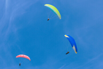 Paraglider flying in the air over hills. Aerial view of flying on a sunny day. 