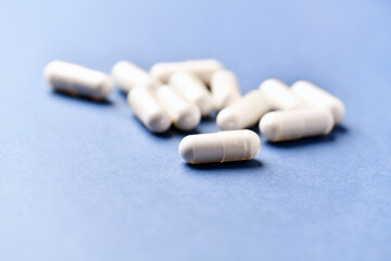 Tyrosine capsules (one of the 20 standard amino acids). A dietary supplement used to improve attention and focus on paper background. Soft focus. Close up.