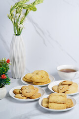 Mix variety of different cookies on the white background with a cup of tea