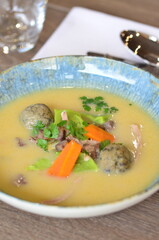 close view of traditional Czech food, Kaldoun goose soup, served food on a plate in a restaurant, wooden table, Saint Martin's goose, traditional Czech holiday food