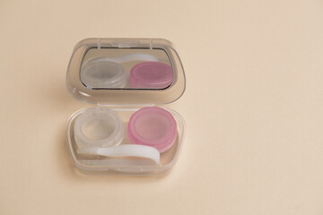 Compact contact lens case on a beige background