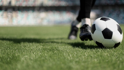 Obraz premium African American man playing football on the stadium field. A man runs with a soccer ball across the field.