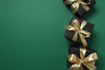 Beautiful gift boxes tied with golden bows on color background 