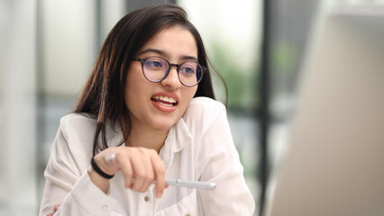 Beautiful young woman working with laptop in her office.