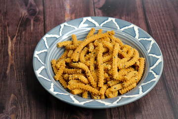 Crunchy fried homemade Chakli sticks with sesame seeds. Chakli is a savory snack from India made out of rice, mixed yellow and green lentils along with spices. Mostly eaten during Diwali festival