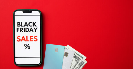 Top view of a smartphone screen displaying a Black Friday online sale on red background with credit cards and money